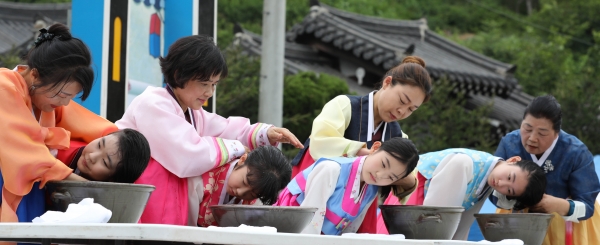 단오 행사에서 창포를 삶은 물에 머리를 감고있는 소녀들의 모습.[자료사진=대전광역시 동구청 제공]
