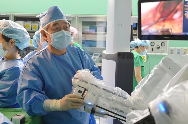 건양대병원 외과 최인석 교수가 환자의 병변부에 로봇 팔을 도킹(결합)하는 모습.[사진=건양대병원 제공]
