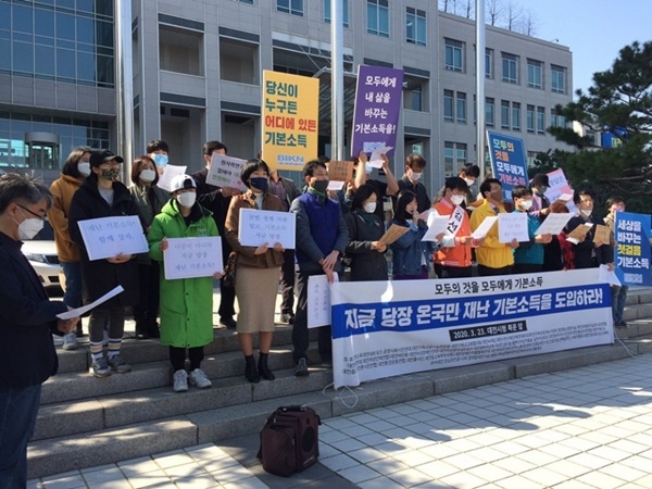 기본소득대전네트워크가 대전시청 북문 앞에서 대전 시민 모두에게 지급하는 '재난 기본소독' 도입을 촉구하는 기자회견을 갖고 있다.