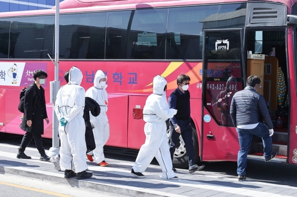대전시 관계자가 대전역에 도착한 해외입국자를 임시 격리시설로 이동시키기 위해 버스 탑승을 안내하고 있다.