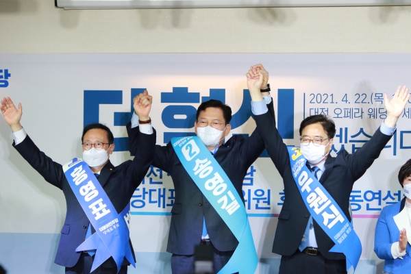 22일 더불어민주당 당 대표에 도전하는 홍영표, 송영길, 우원식 후보가 대전 합동연설회에서 함께 손을 잡고 지지를 호소 하고 있다.